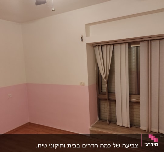 חדר צבוע בצבע ורוד ולבן עם וילונות על החלון
